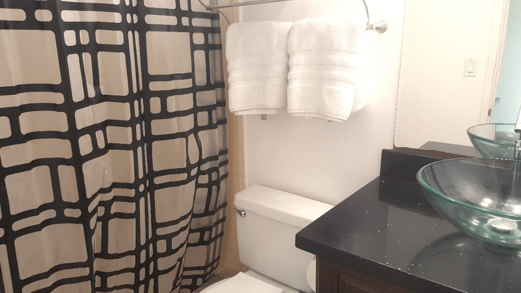 A Bathroom Space With a White Shower Curtain